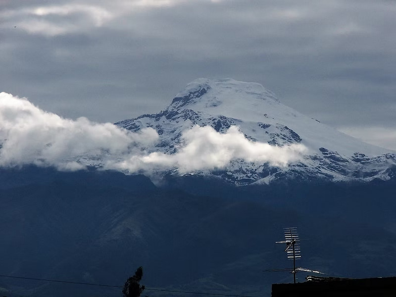 Cayambe peak showing through the clouds from town in Ecuador