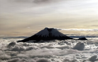 Volcano in the distance breaching the clouds for an amazing view of Volcan Cayambe, Ecuador