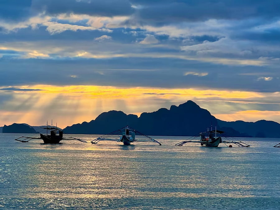 Sun setting over the islands and boats of Palawan Philippines in paradise